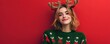 © dreamdes - Smiling young woman wearing deer antlers isolated on red background. Holiday reindeer party costume. Christmas and New Year celebration. Banner with copy space