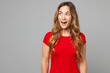 © ViDi Studio - Young shocked surprised impressed fun cool excited happy woman she wear red t-shirt casual clothes look aside on empty area mock up isolated on plain grey background studio portrait Lifestyle concept