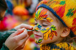 © dK - Child getting colorful autumn-themed face paint, with vibrant leaves design, celebrating the fall season in a joyful outdoor event