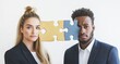 © dakinya - Serious businesswoman and businessman holding puzzle pieces, symbolizing partnership, teamwork, and problem-solving in business, standing against a neutral background, selective focus