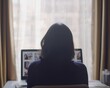 © Espresso - A woman sits in front of a laptop, browsing photos on a website.