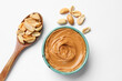 © New Africa - Tasty peanut butter in bowl and spoon with groundnuts on white table, flat lay