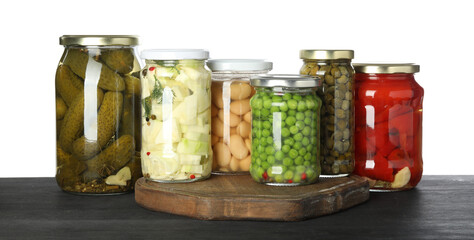 Canvas Print - Different pickled products in jars on dark wooden table against white background