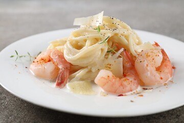 Delicious pasta with shrimps and cheese on grey table, closeup