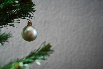 Christmas tree on a gray background with a gray New Year's ball for a blank card