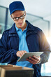 © CamPen2000/peopleimages.com - Logistics, man and tablet in office for checklist, delivery and inspection for customer service. Courier guy, glasses and tech at boxes for quality control, inventory management or check client order