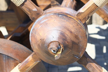 Poster - A detailed view of a wooden wheel with ropes wrapped around it, suitable for use in historical or rustic themed contexts