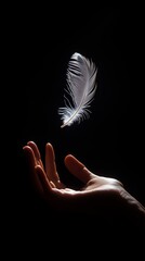 Canvas Print - A delicate white feather gently floats above an outstretched hand in a darkened space, capturing a moment of tranquility and wonder