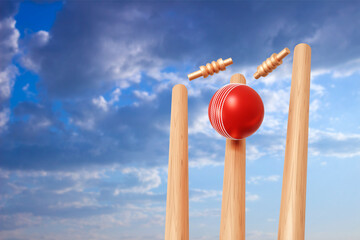 Wall Mural - Cricket ball hitting wicket stumps against blue sky background. 3d-rendering