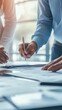 © Oran - Close-Up of Business Professionals Collaborating on Documents in Office