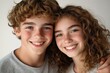 © Alexandr - Smiling curly-haired siblings embracing with joy