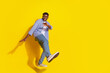 © deagreez - Photo of young american guy wearing casual checkered shirt and jeans clubbing carefree dancer isolated on yellow color background