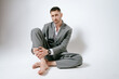 © Elina Leonova - Handsome man in grey suit sits on the floor barefoot