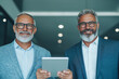 © Vertigo Images - Two businessmen in suits holding a tablet.