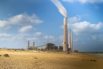 Air pollution from a power station, global warming, beach pollution