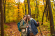 © Zoran Zeremski - Smiling couple with backpacks hiking together in forest.
