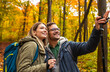 © Zoran Zeremski - Smiling couple with backpacks hiking together in forest.