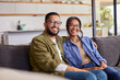 © Rido - Smiling multiethnic couple looking at camera at home