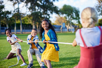 Happy children playing tug of war