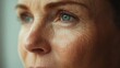 © Plaifah - A close-up of a 50-year-old woman skin under natural light, highlighting her fine lines and natural texture, with a soft and serene expression.