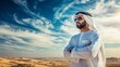 © Oulaphone - A man in traditional attire stands confidently in a vast desert under a blue sky, wearing sunglasses and enjoying the sunny atmosphere.