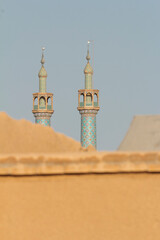 Street view of the minarets of the Grand Mosque in Yazd, Iran with fine details of tile work patterns.