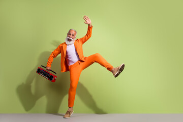 Poster - Full body portrait of funky eccentric handsome grandfather dance boombox wear orange suit isolated on green color background