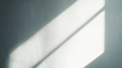 Poster - Soft light filters through a window, casting delicate shadows on a plain wall. The varying intensities of light reveal the textured surface, creating a tranquil atmosphere indoors