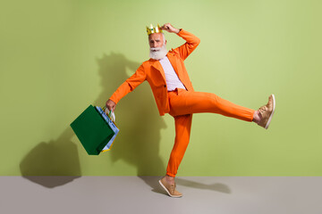 Canvas Print - Full size photo of attractive retired man king dance shopping bags dressed stylish orange fancy clothes isolated on green color background