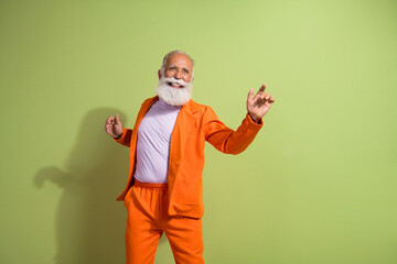 Poster - Portrait of funky eccentric grandfather dancing wear orange suit isolated on green color background