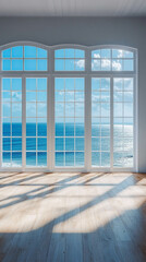 A vertical photo of an empty living room with a wooden floor and a bright window with a light blue ocean view