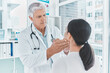 © CourtH/peopleimages.com - Healthcare, medical or throat with doctor and patient in hospital for diagnosis or feedback. Consulting, medicine or thyroid with mature professional man and woman in clinic for physical exam