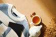 © photoguns - Autumn flat lay composition with cup of tea, teapot, warm knitted sweater with book, dry flowers on brown table. Fall, cozy home still life.