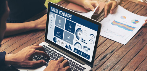 Human resources management software on computer screen helping human resources employee to manage recruitment, payroll, staff searching and KPI evaluation snugly