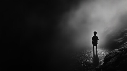 Canvas Print - A silhouetted child stands alone on a rocky path shrouded in mist during twilight in a serene natural setting