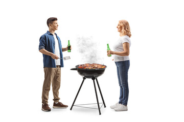 Canvas Print - Man and woman drinking beer and cooking meat on a bbq