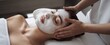 © Gusteau - Woman receiving a facial massage with a white mask on her face at a spa. Generative-AI