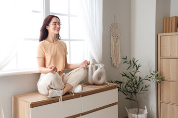 Sticker - Young woman meditating on commode at home