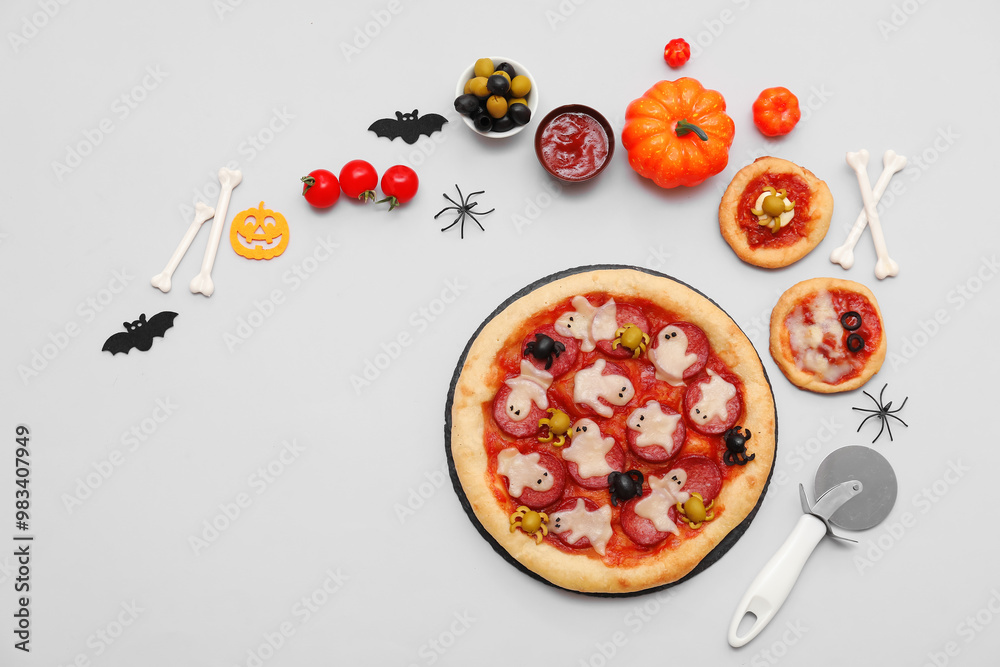 Composition with tasty Halloween pizzas, ingredients and decorations on grey background
