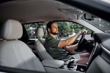 Wall Mural - Man driving a car in a modern interior with soft lighting