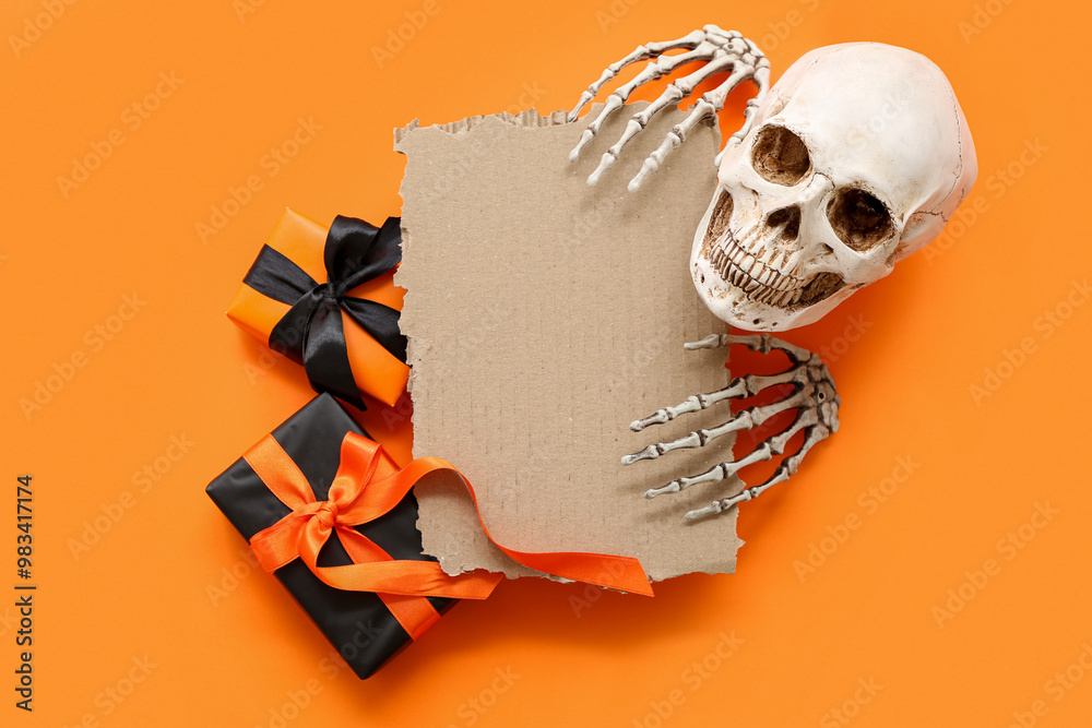 Blank cardboard, gifts and Halloween decorations on orange background, top view