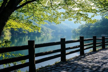 Wall Mural - Peaceful lake scene with wooden fence, green foliage, and sunlight. Tranquil nature background for travel, vacation, and relaxation.