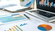© bteeranan - A workspace featuring a laptop and various colorful graphs and charts, emphasizing data analysis and business reporting.