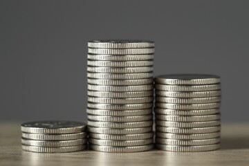 Wall Mural - Stacked coins on wooden table against grey background, closeup. Salary concept