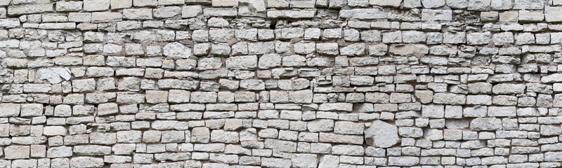 Wall Mural - stone wall made of old cobblestones, gray brickwork background