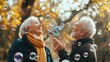 © Nataliya - Happy active senior couple having fun blowing soap bubbles in park outdoors. Vitality and active senior couple concept