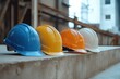 © stock.metket.com - A row of four different colored hard hats (blue, orange,