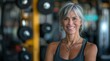 © James - Beautiful senior woman with a perfect body, smiling and posing at the gym after her workout.