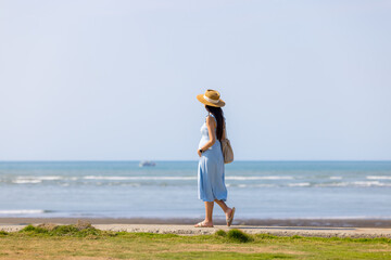 Sticker - Asian pregnant woman walk along the seaside