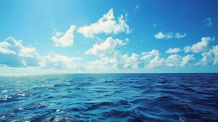 A beautiful scene of the blue ocean against the blue sky background. The ocean stretches out as far as the eye can see, with its surface glistening in the sunlight